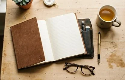 Carnet ouvert et bureau de travail pour réfléchir à une décision professionnelle